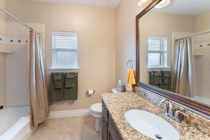Full bathroom with tiled shower / bath, vanity, and plenty of natural light