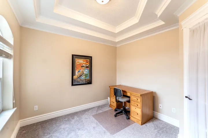 Carpeted home office with crown molding and baseboards