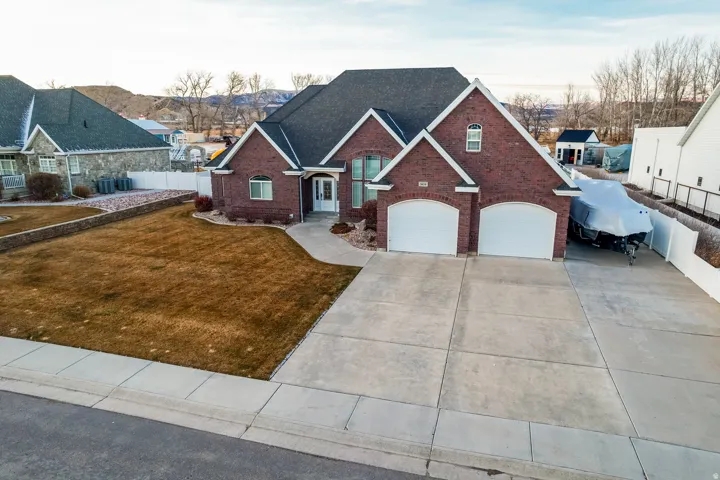 Traditional-style home with brick siding, an attached garage, concrete driveway, and a residential view