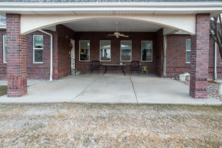 Back of house featuring a patio area, ceiling fan, and brick siding