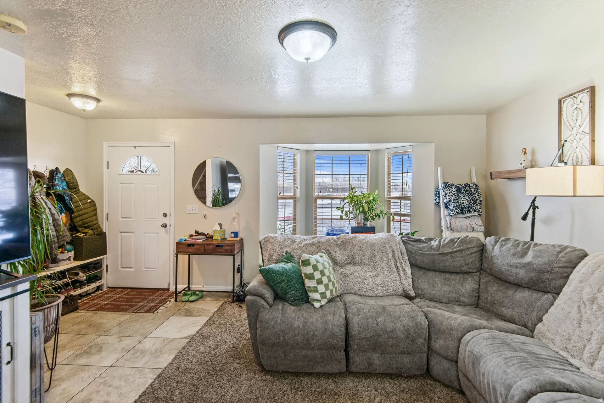 Tiled living area featuring a textured ceiling