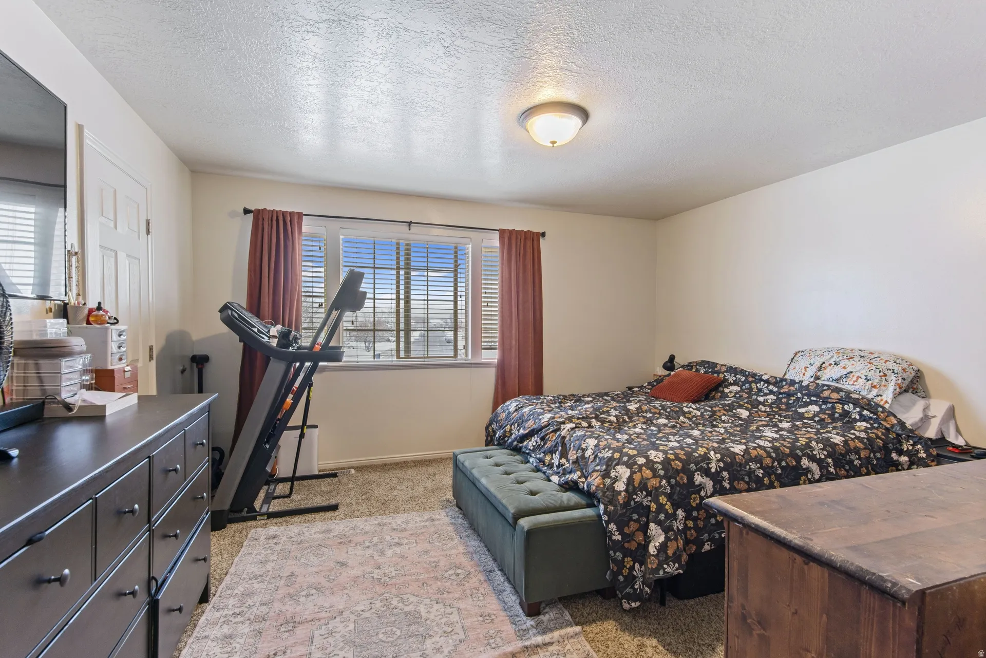 Bedroom featuring light carpet and a textured ceiling