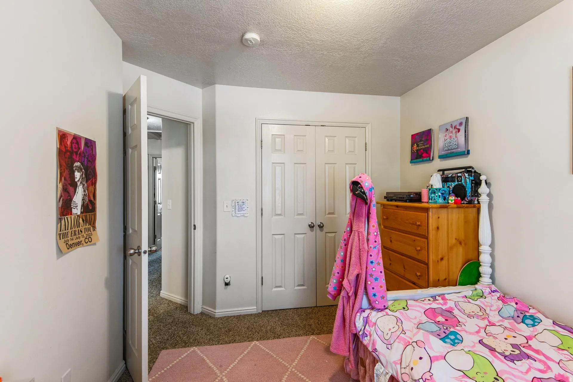 Bedroom with a closet, carpet flooring, and a textured ceiling