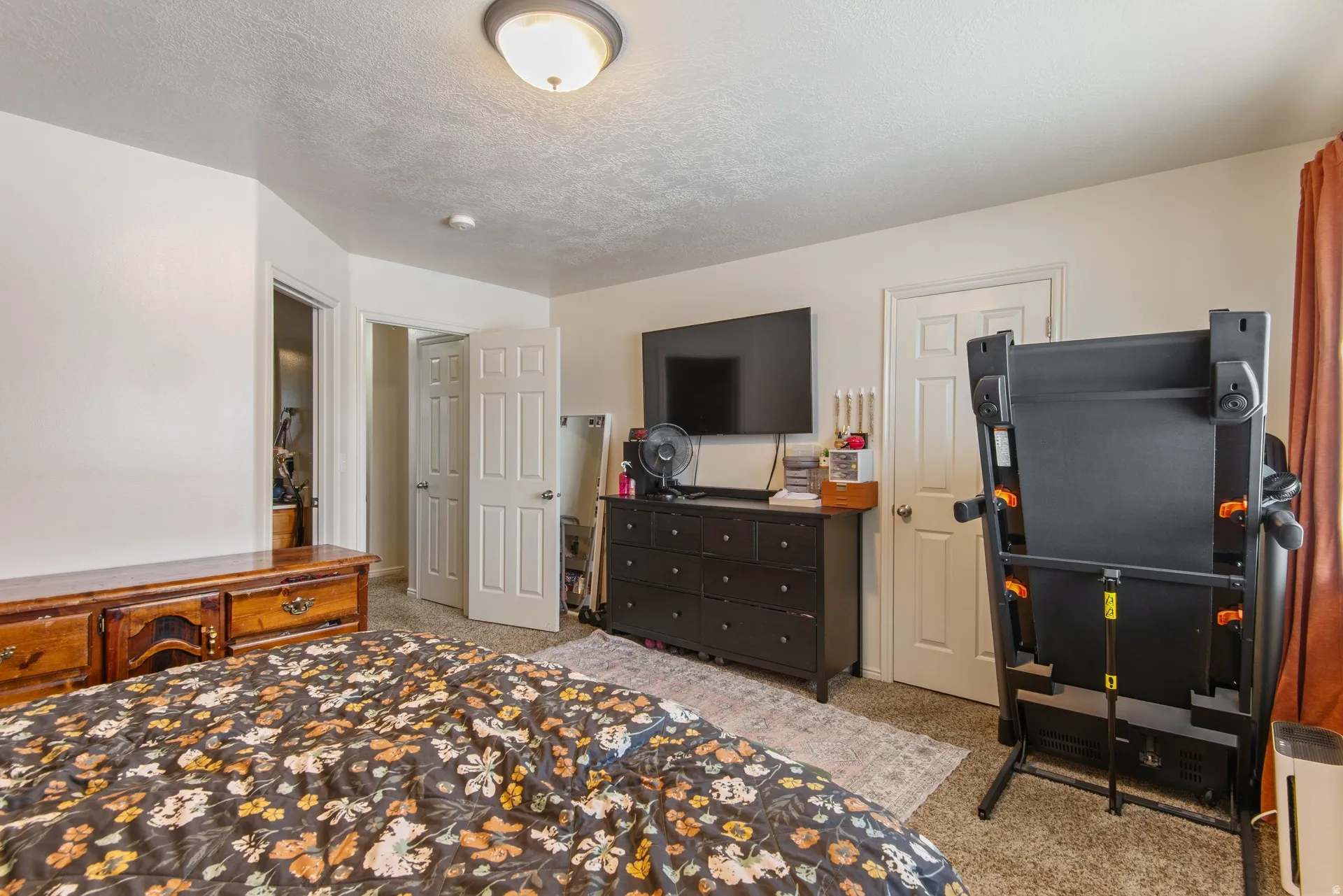 Bedroom with light carpet and a textured ceiling
