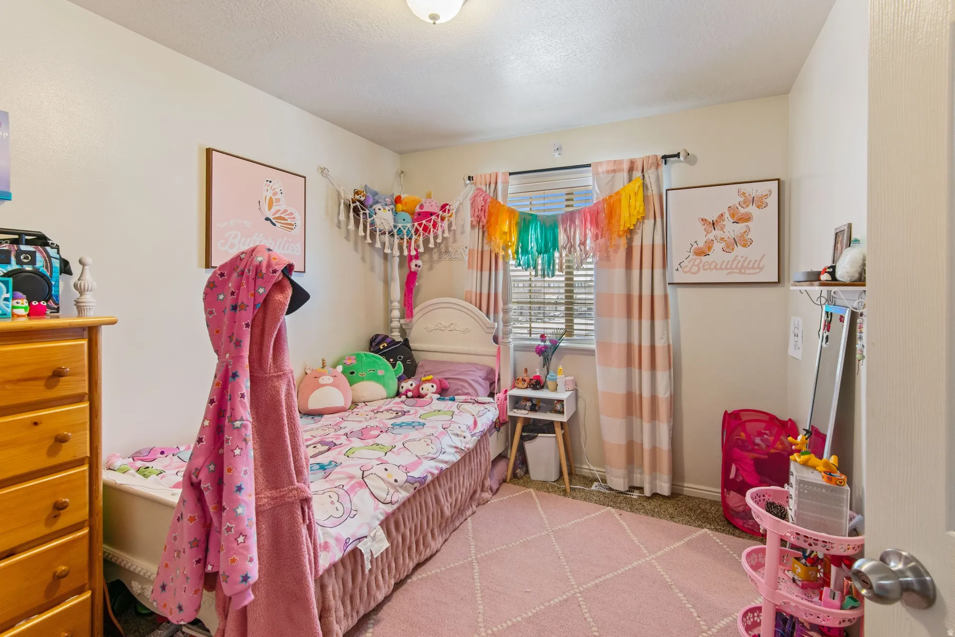 Bedroom with light carpet and a textured ceiling