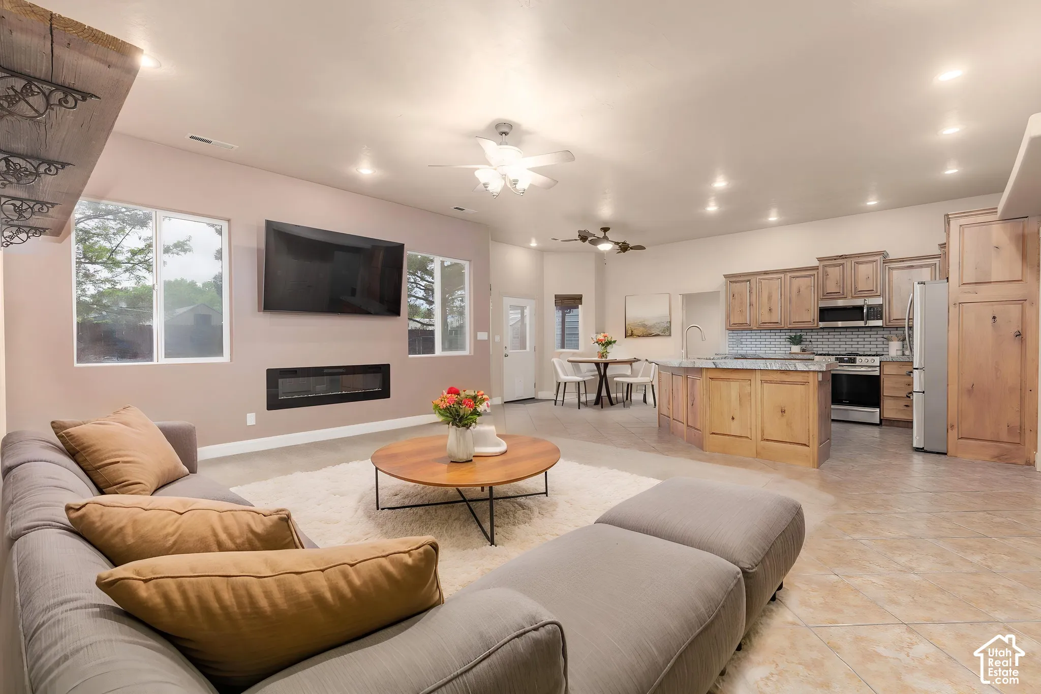 Living room featuring ceiling fan, light tile patterned floors, a glass covered fireplace, and recessed lighting, AI staged
