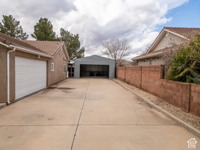 View of detached garage and large extended pad