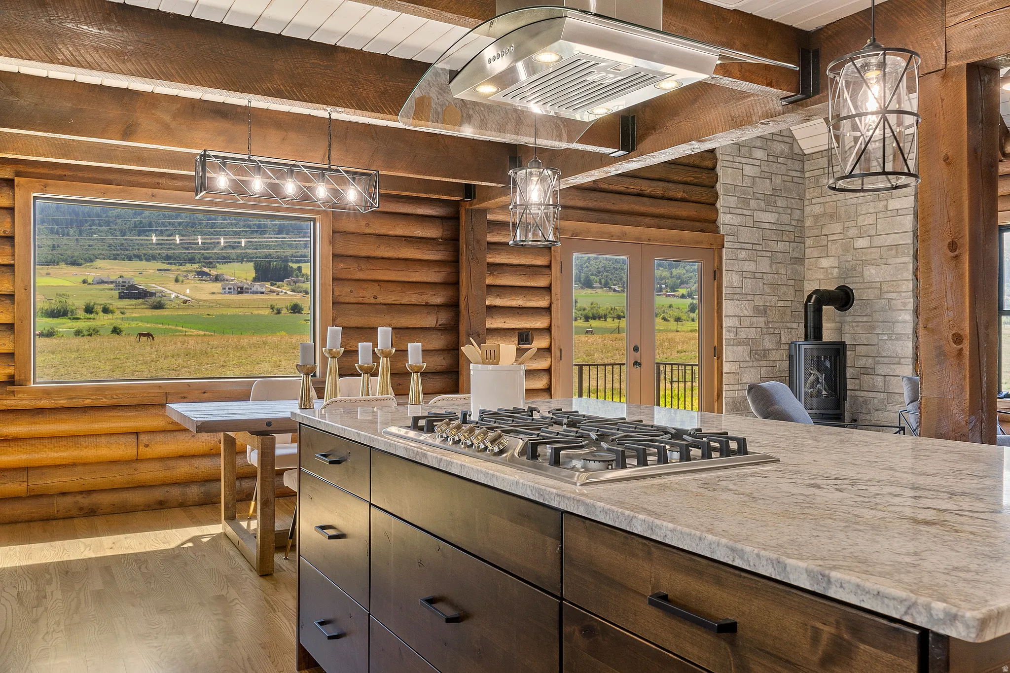 Kitchen with log walls, french doors, dark wood finish cabinetry, light wood finished floors, and decorative light fixtures