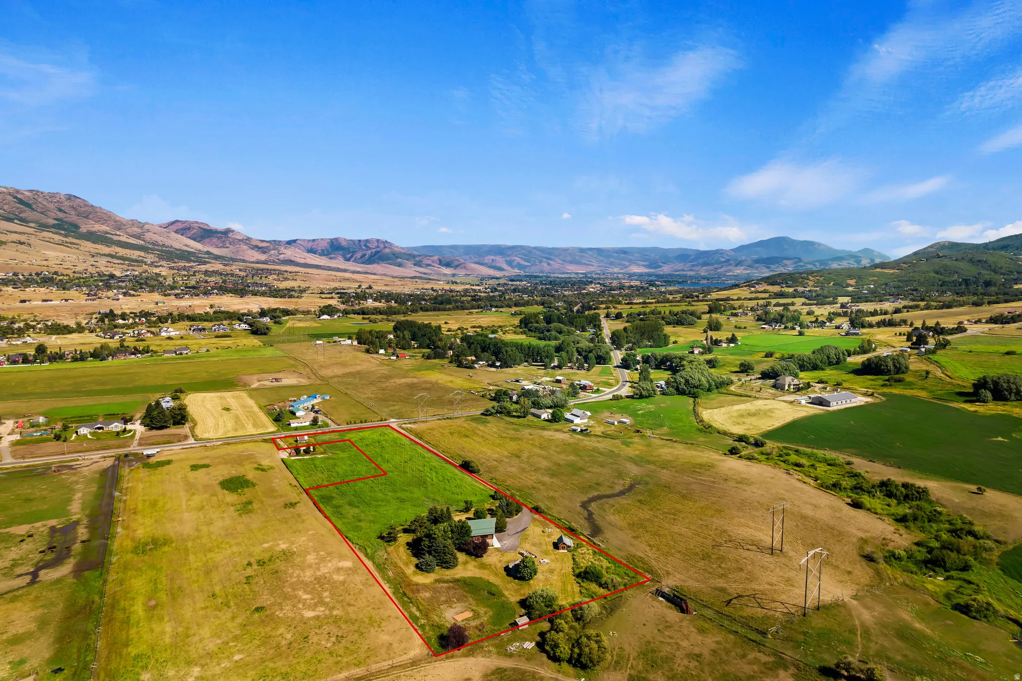 Overview of rural landscape with property boundaries highlighted and a mountainous background