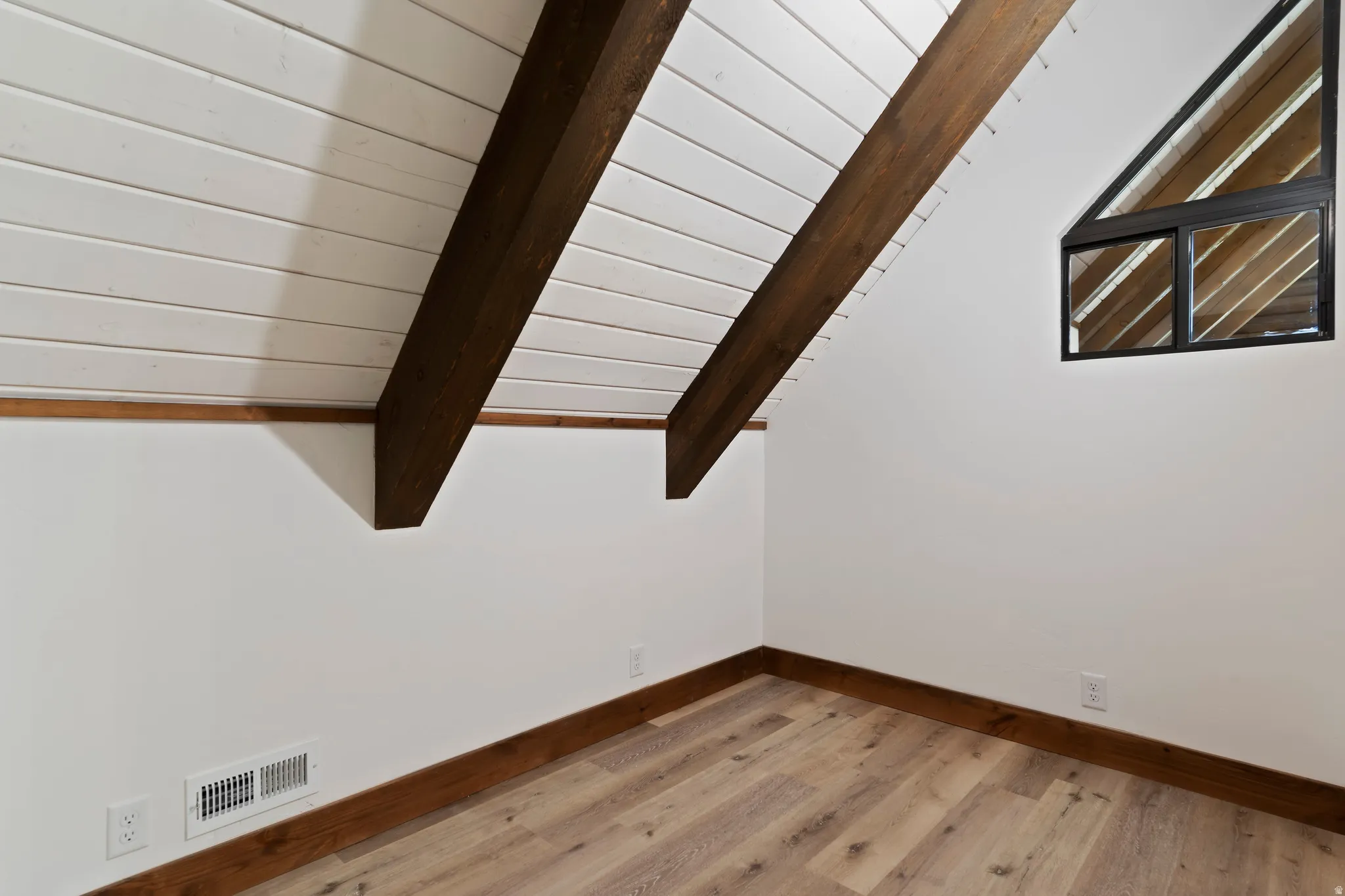 Detailed view of wood finished floors and a wood ceiling with exposed beams