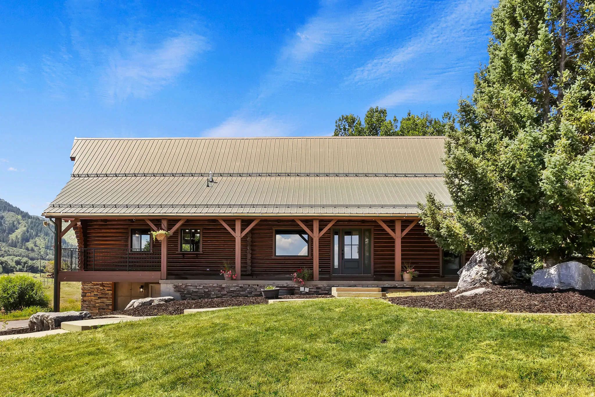 Cabin featuring a metal roof, a front lawn, and covered porch