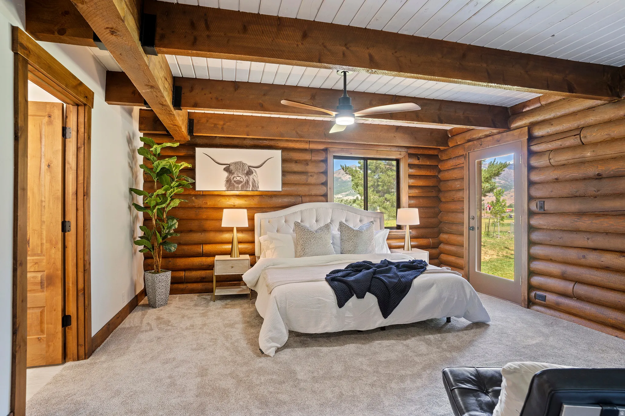 Bedroom featuring carpet floors, rustic walls, and a wood ceiling with exposed beams
