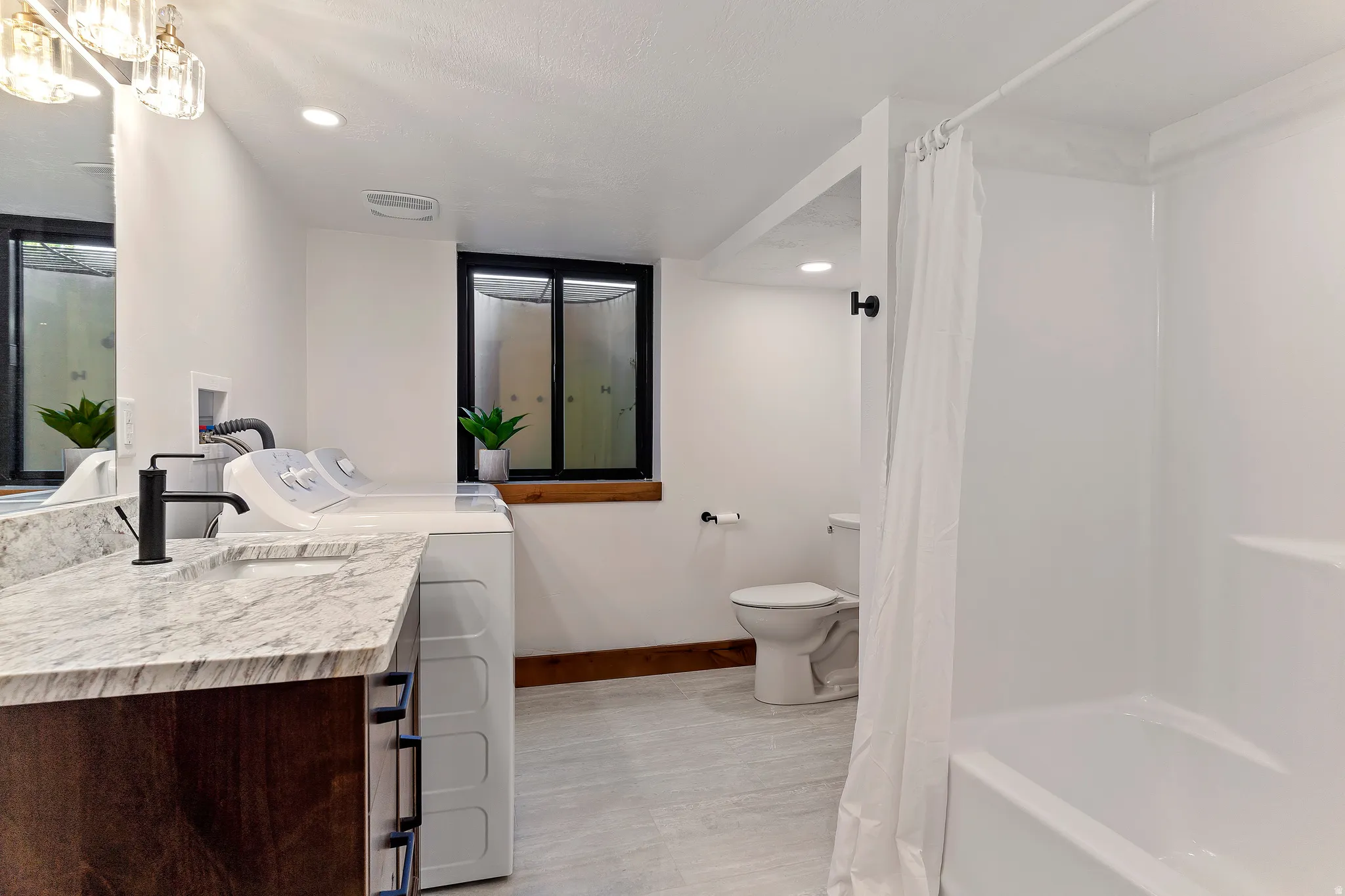 Full bath with vanity, shower / tub combo, recessed lighting, separate washer and dryer, and light wood-style floors