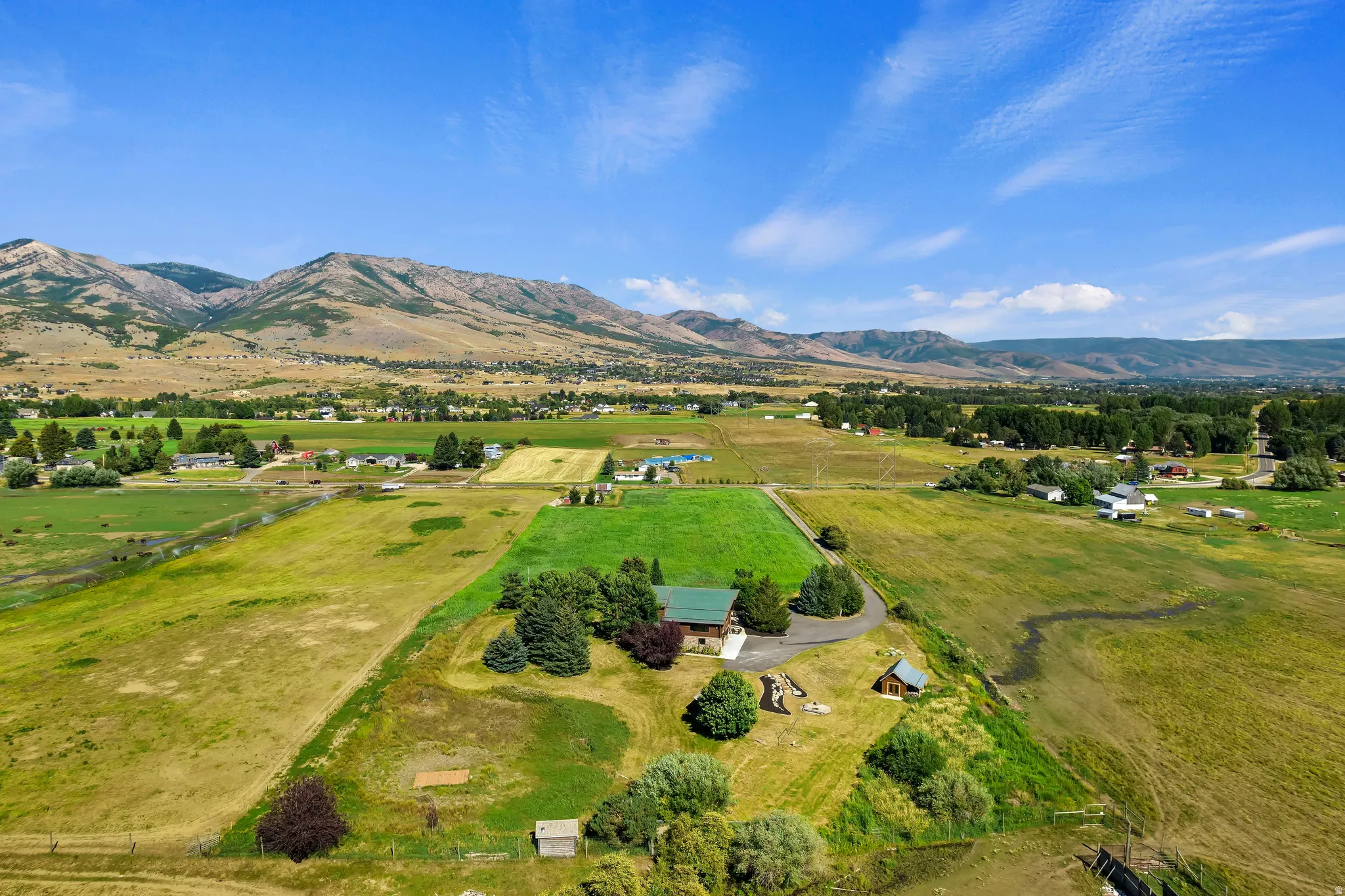 Aerial view of sparsely populated area featuring a mountainous background and agricultural land