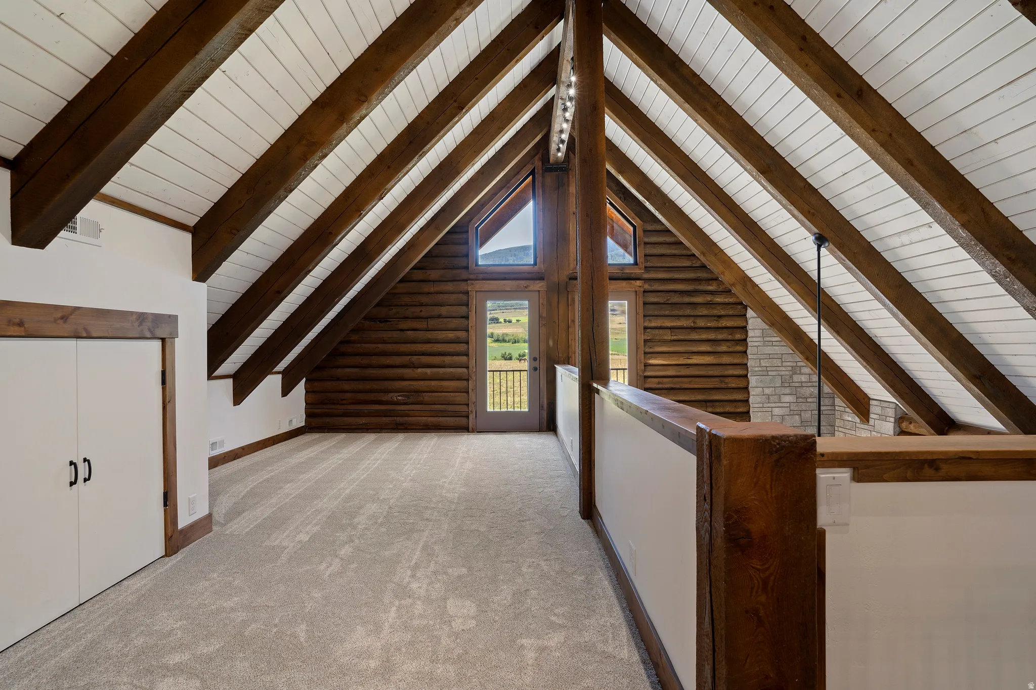 Additional living space with light colored carpet and a wood ceiling with exposed beams