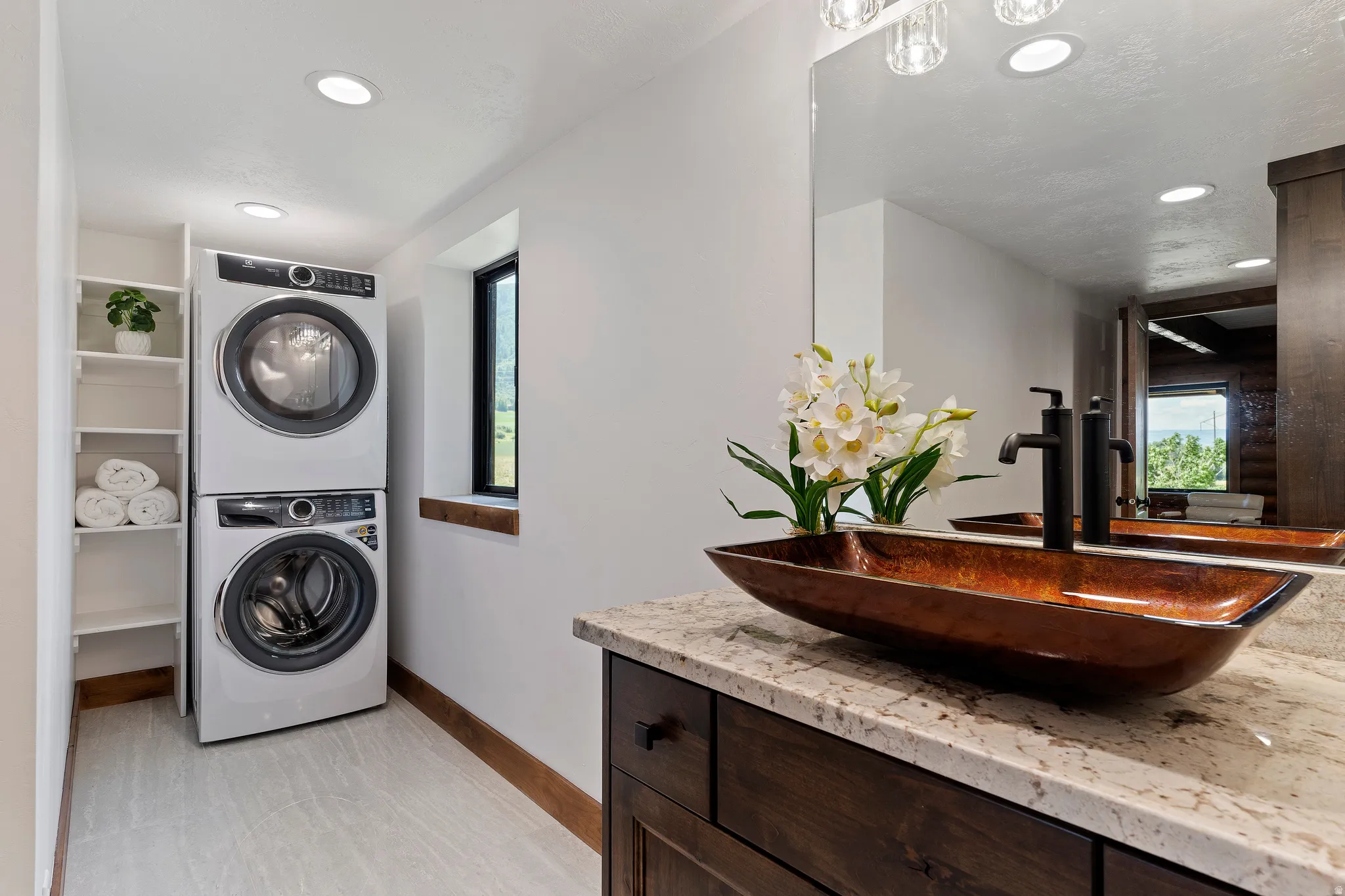 Laundry room featuring stacked washer / dryer, recessed lighting, and plenty of natural light