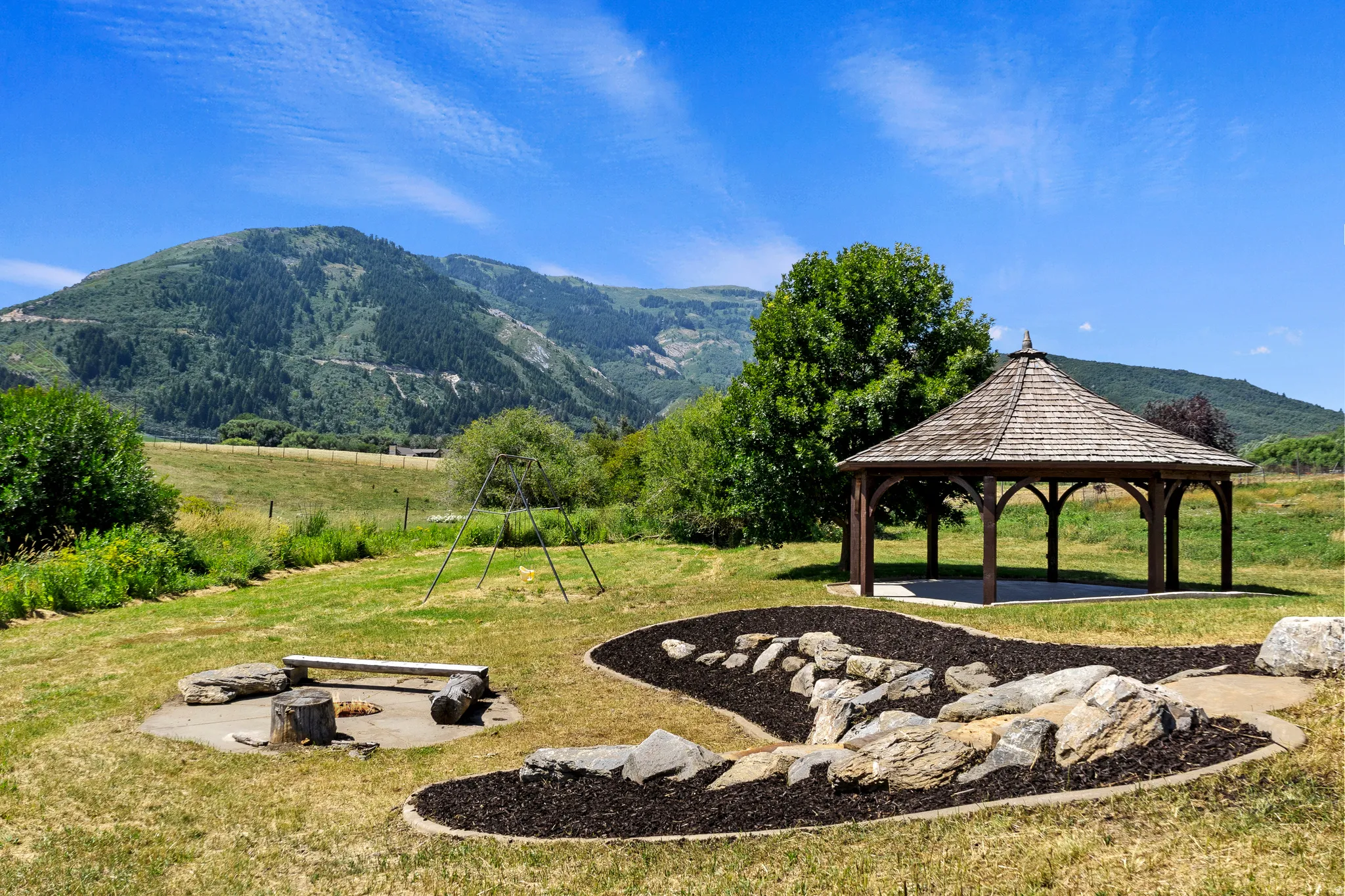 View of community with a mountain view, a patio area, a fire pit, and a gazebo