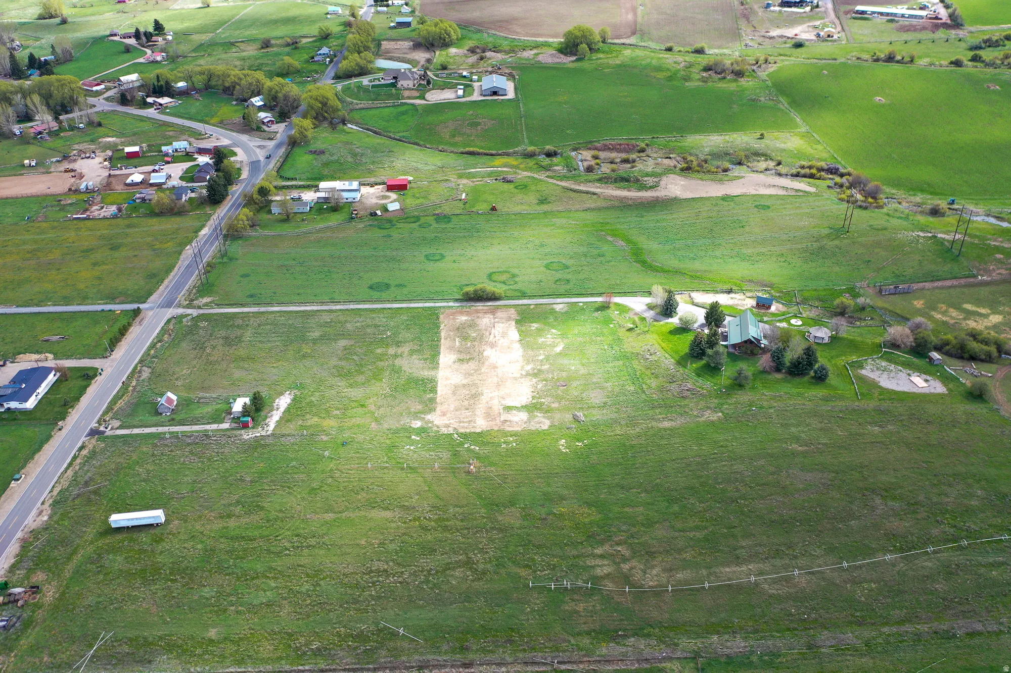 Aerial view of property and surrounding area featuring rural landscape and agricultural land