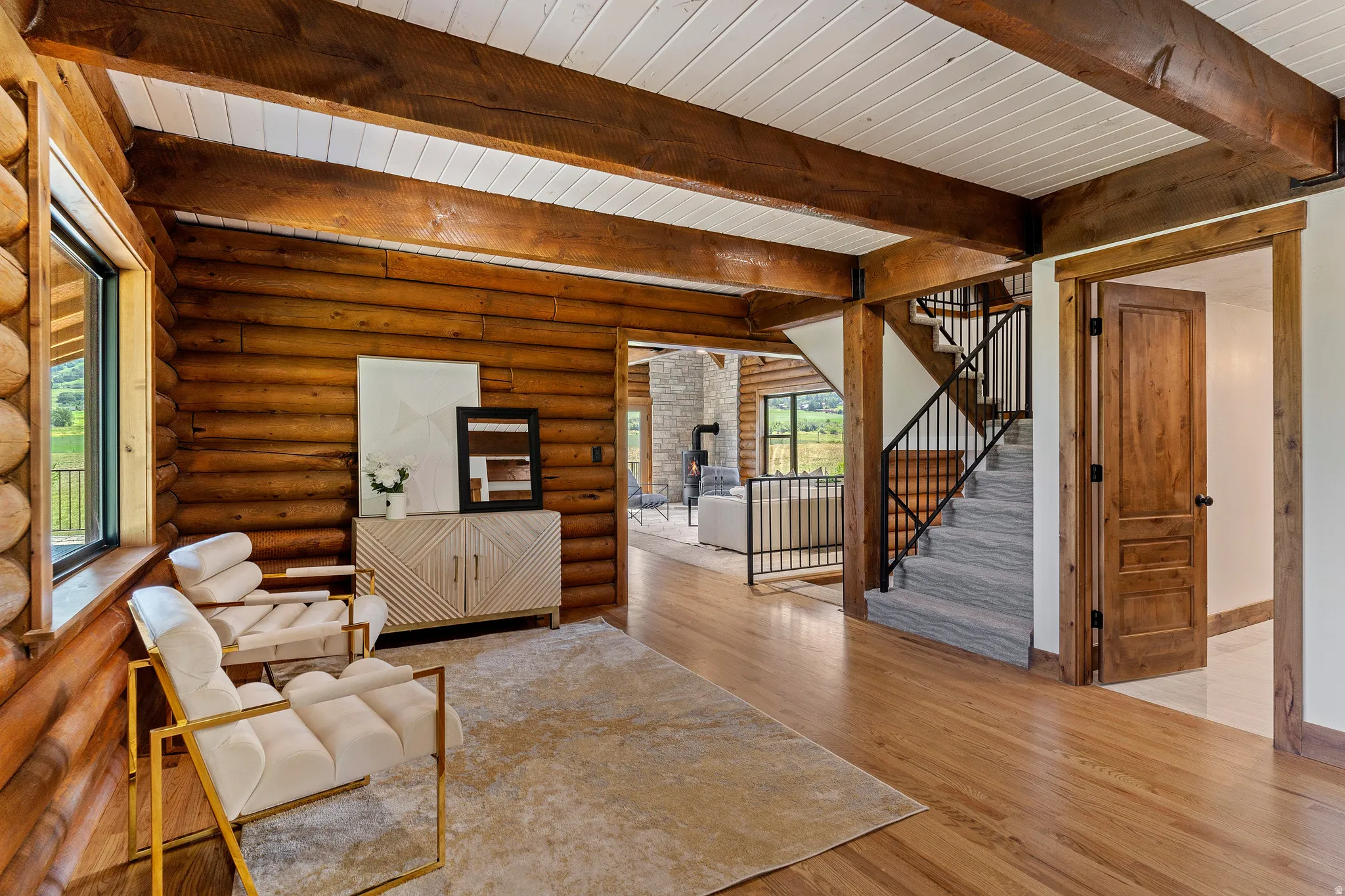 Living room featuring wood finished floors, rustic walls, and a wood ceiling with exposed beams