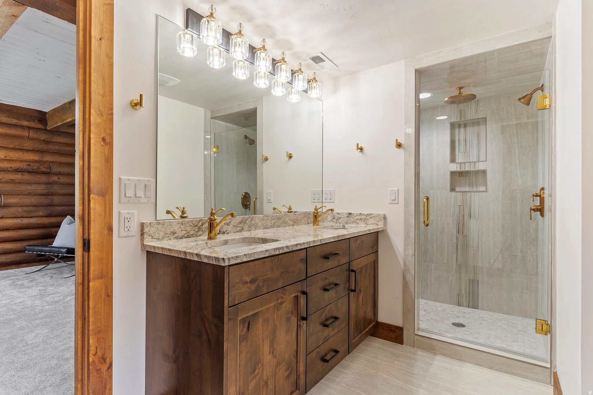 Bathroom with a stall shower, double vanity, and log walls