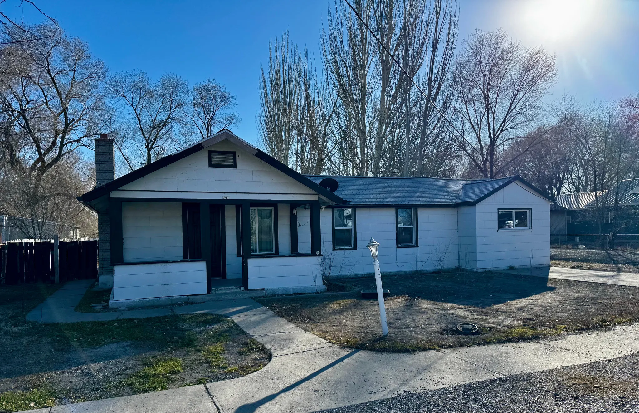 Single story home featuring a chimney and a porch