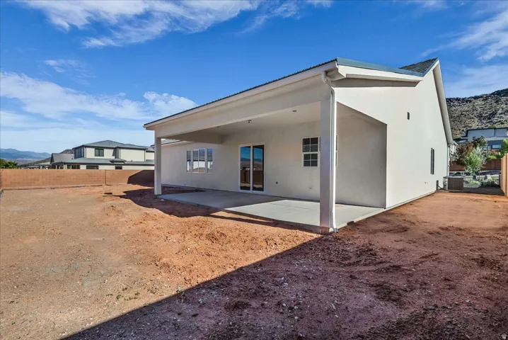 Rear view of property with stucco siding, a patio area, and a mountain view