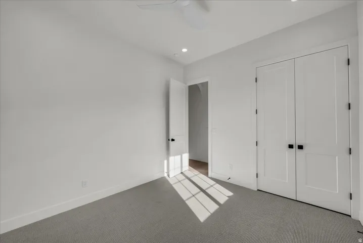 Unfurnished bedroom featuring carpet floors, a closet, recessed lighting, and a ceiling fan