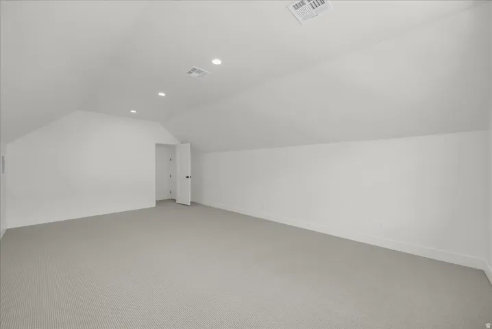 Bonus room featuring light carpet, vaulted ceiling, and recessed lighting
