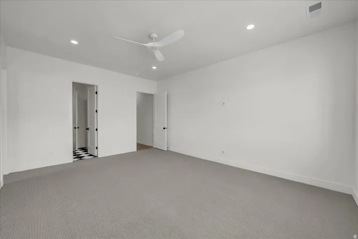 Carpeted spare room with ceiling fan and recessed lighting