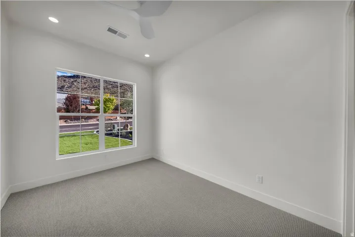 Carpeted spare room featuring a ceiling fan and recessed lighting
