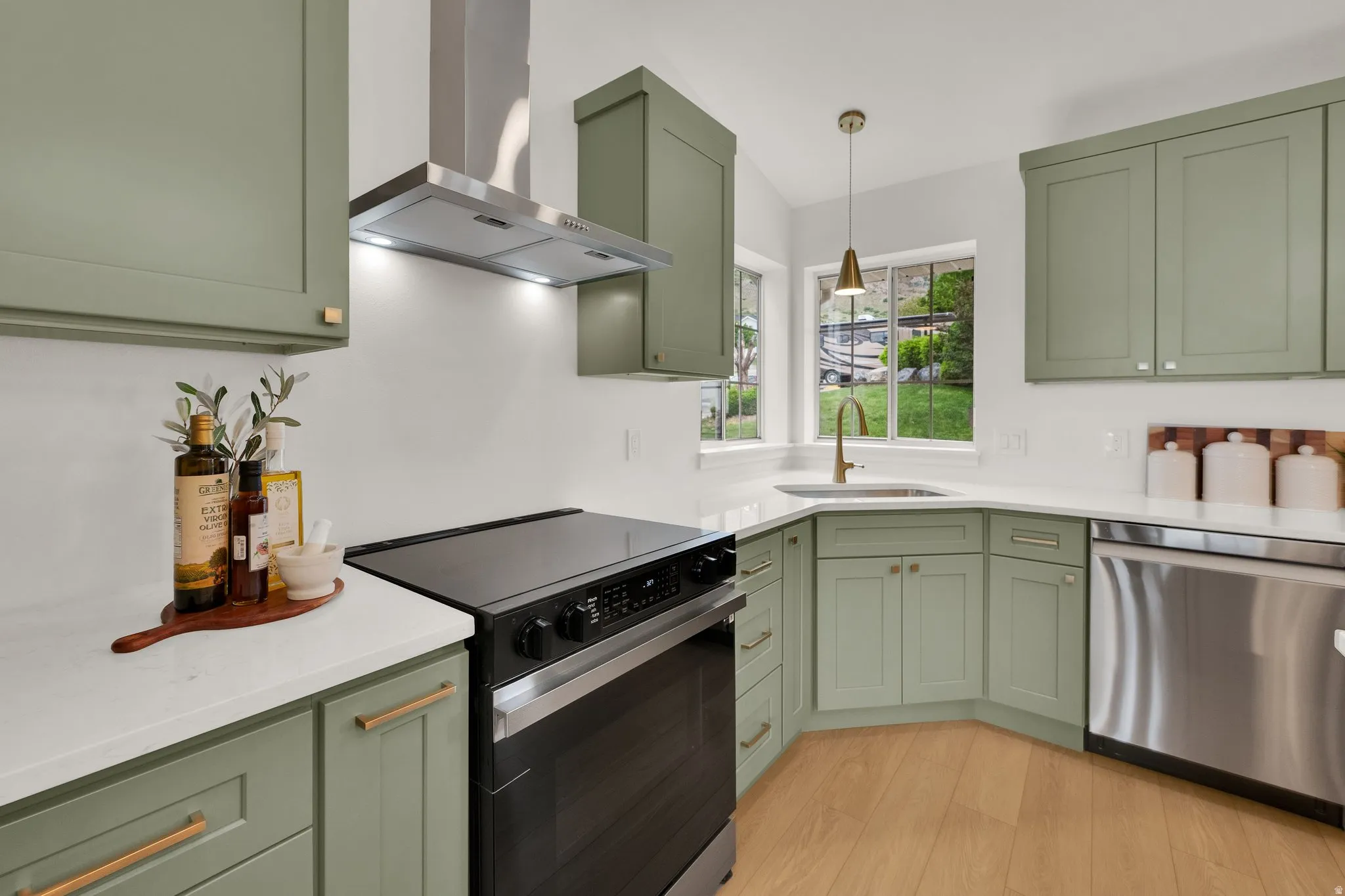 Kitchen featuring green cabinetry, range with electric cooktop, extractor fan, stainless steel dishwasher, and lofted ceiling