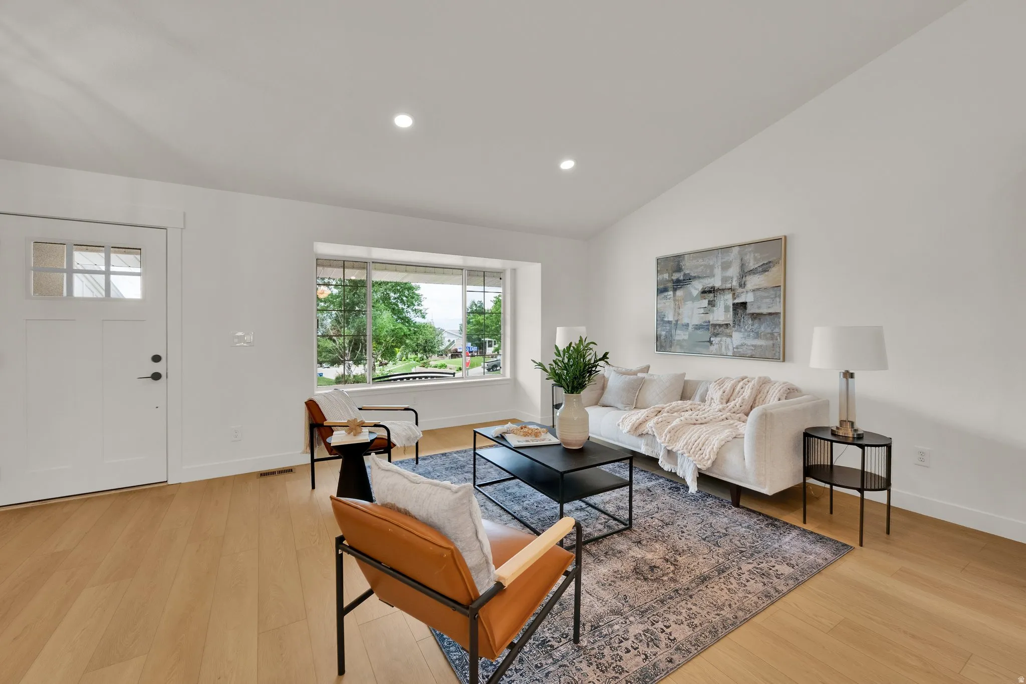 Living room with light wood-style floors, recessed lighting, and lofted ceiling