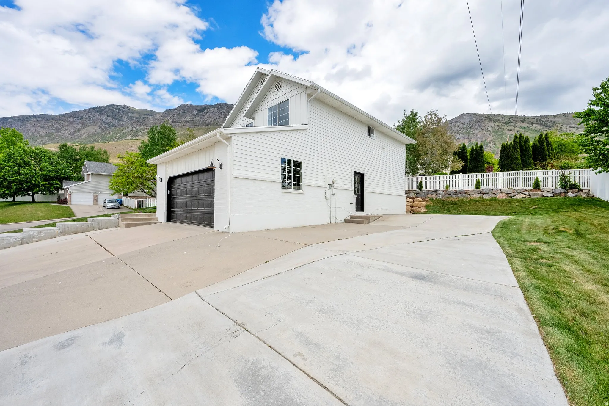 View of side of property featuring a mountain view, driveway, and an attached garage