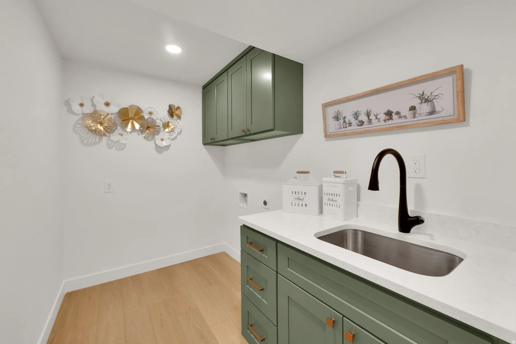 Basement Laundry area featuring light wood-type flooring, cabinet space, hookup for a washing machine, hookup for an electric dryer, and recessed lighting