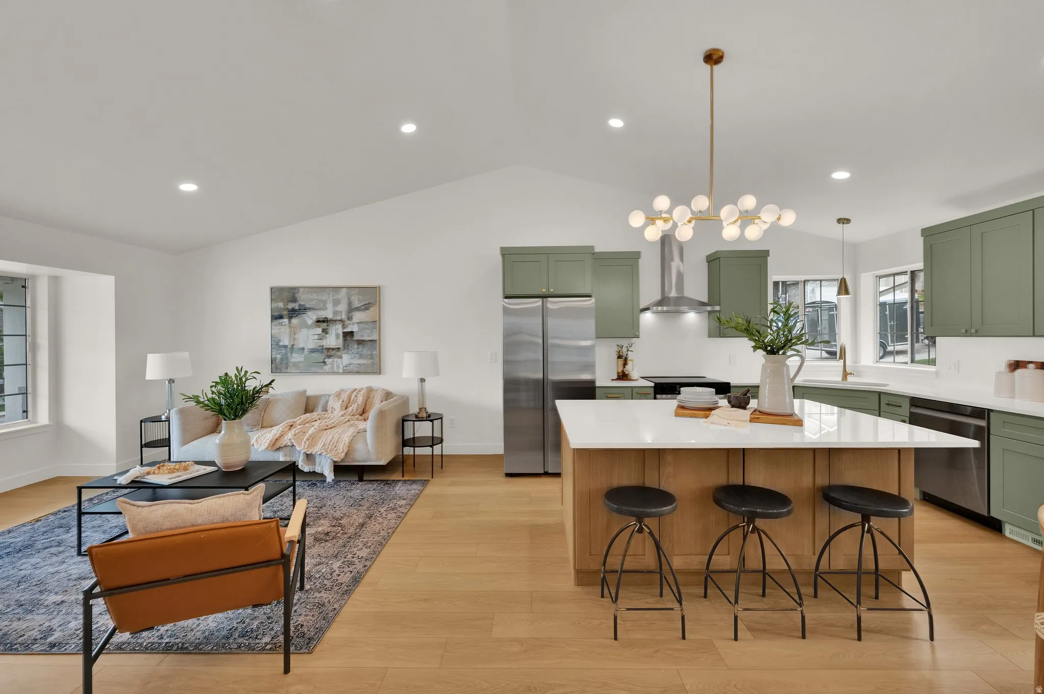 Kitchen with a center island, stainless steel appliances, light wood finished floors, light stone counters, and vaulted ceiling