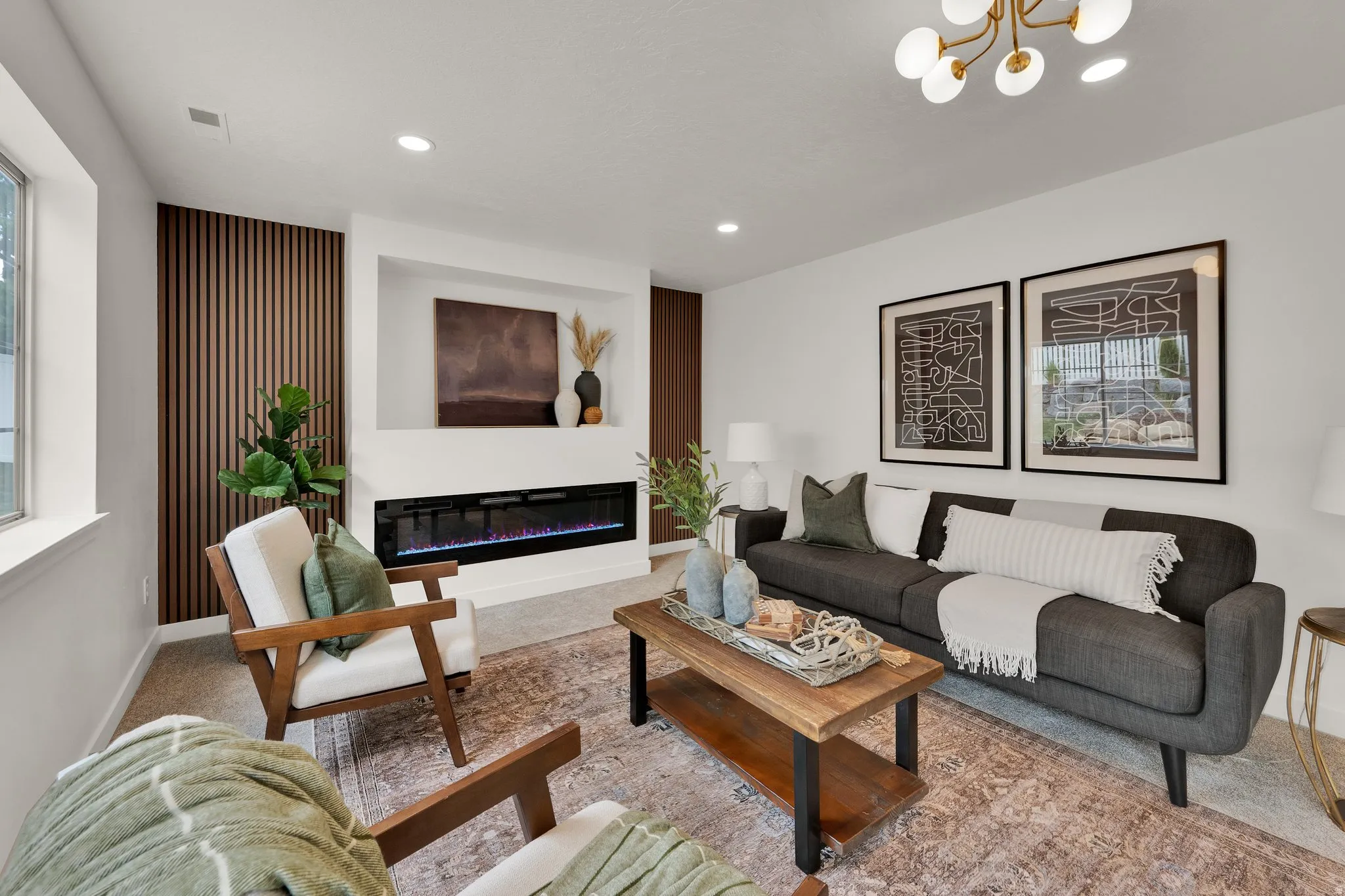 Carpeted living room featuring a glass covered fireplace and suspended lighting