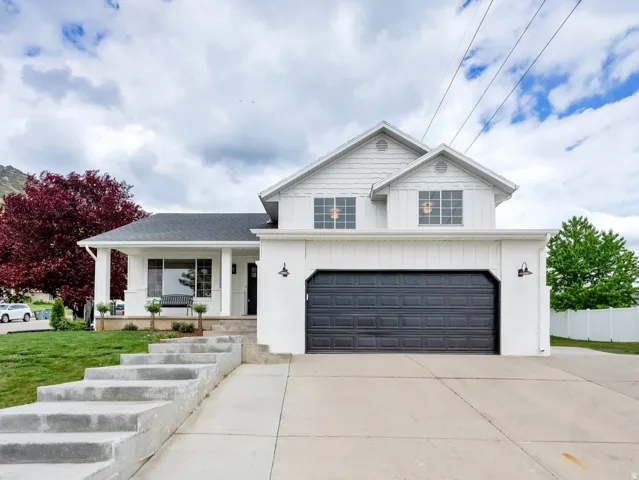 View of front of home with covered porch, driveway, a garage, and board and batten siding