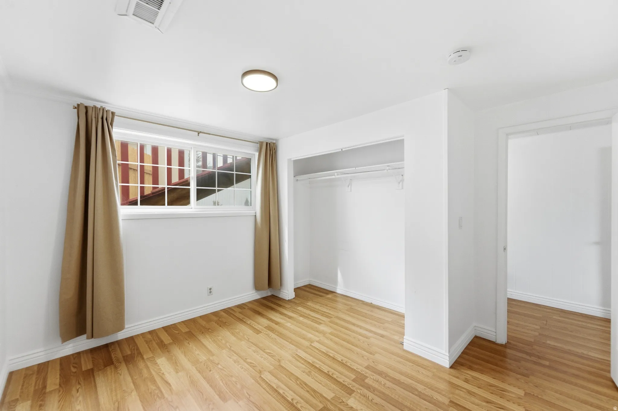 Unfurnished bedroom with a closet and light wood-style flooring