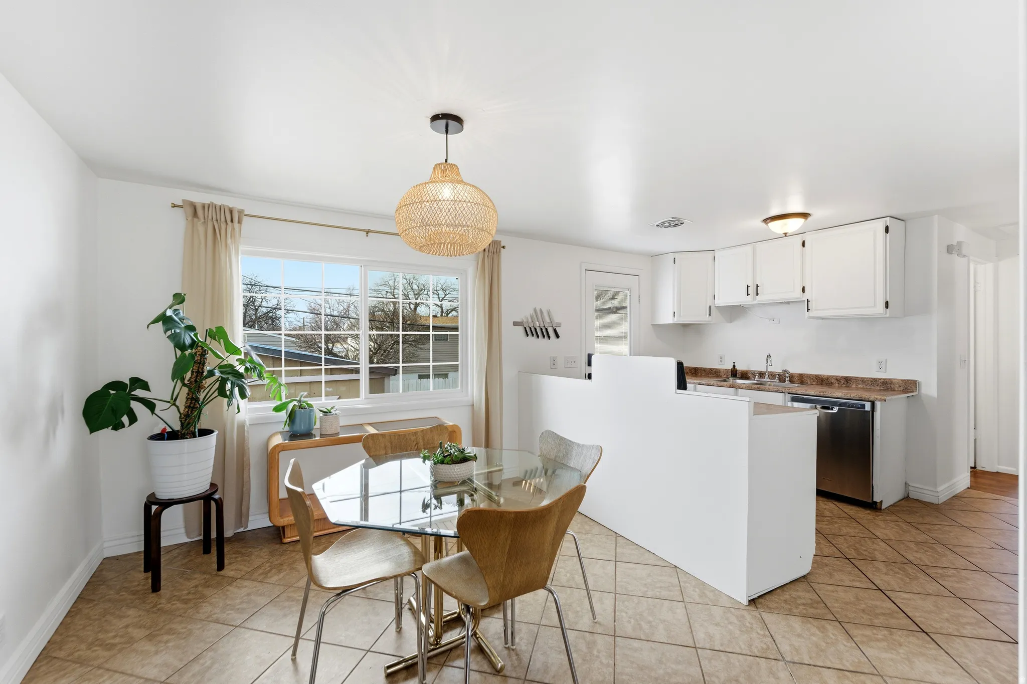 Dining space with light tile patterned flooring and baseboards