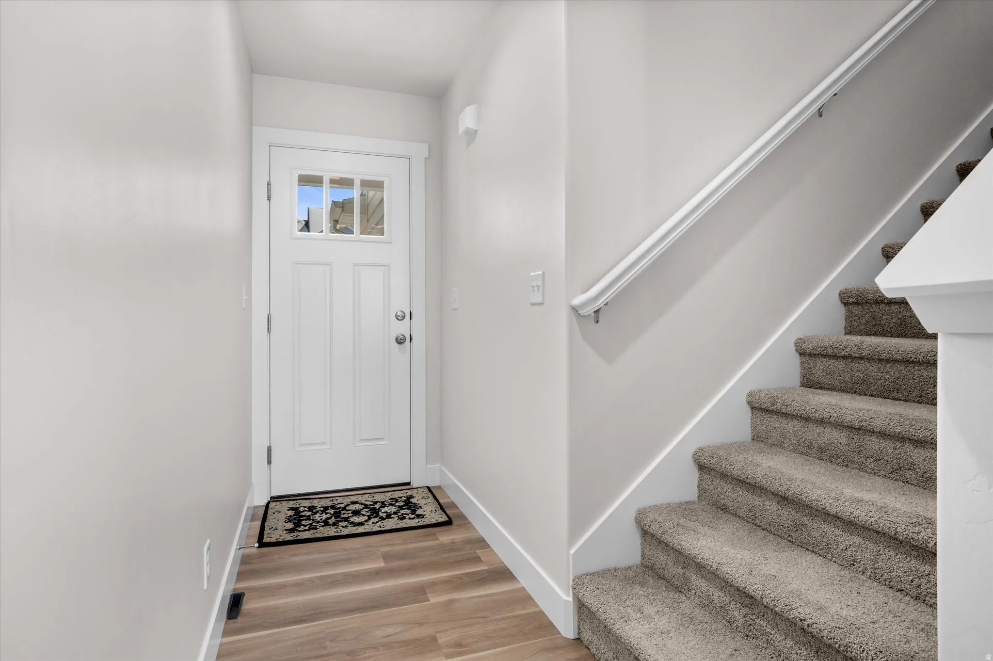 Foyer entrance with stairs and light wood finished floors