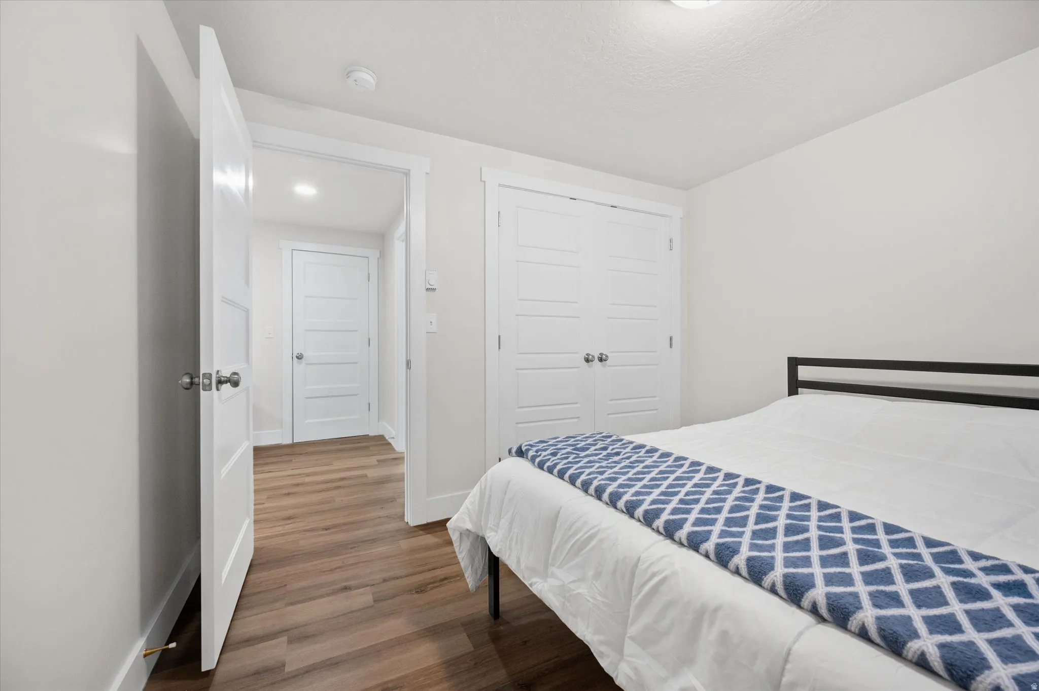 Bedroom with wood finished floors and a closet