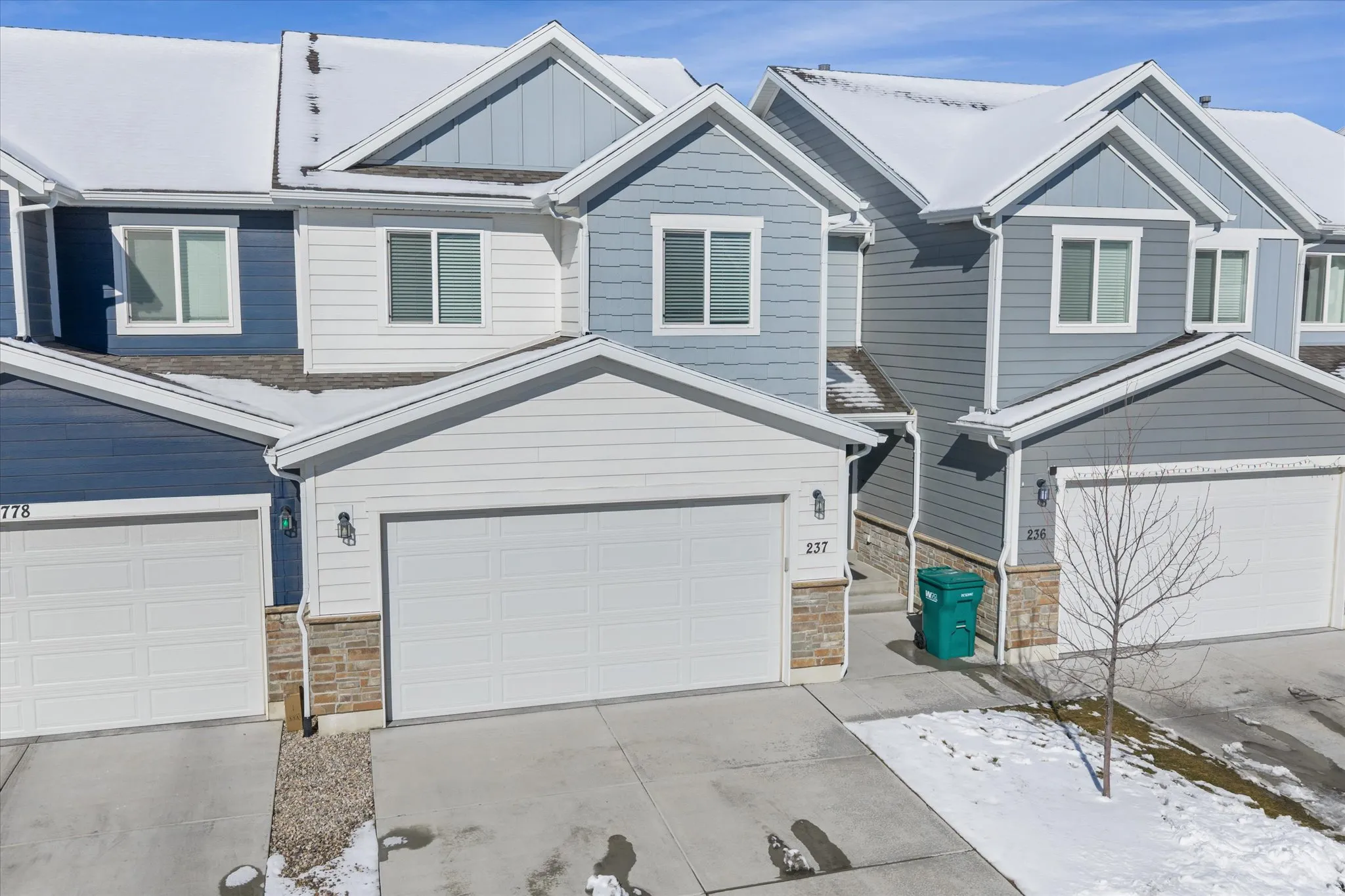 Craftsman-style house featuring stone siding, board and batten siding, driveway, and an attached garage