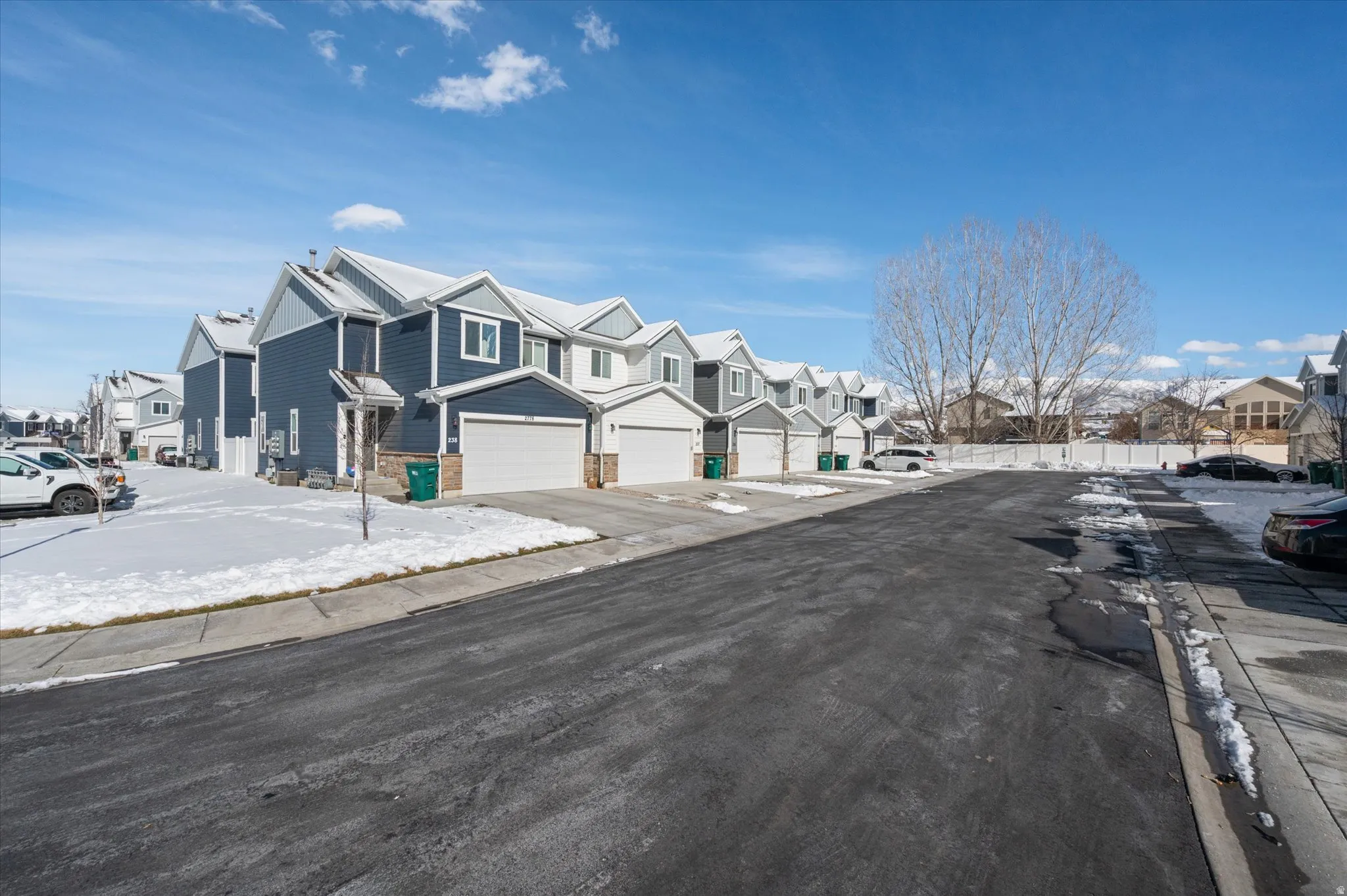View of asphalt street with a residential view, sidewalks, and curbs
