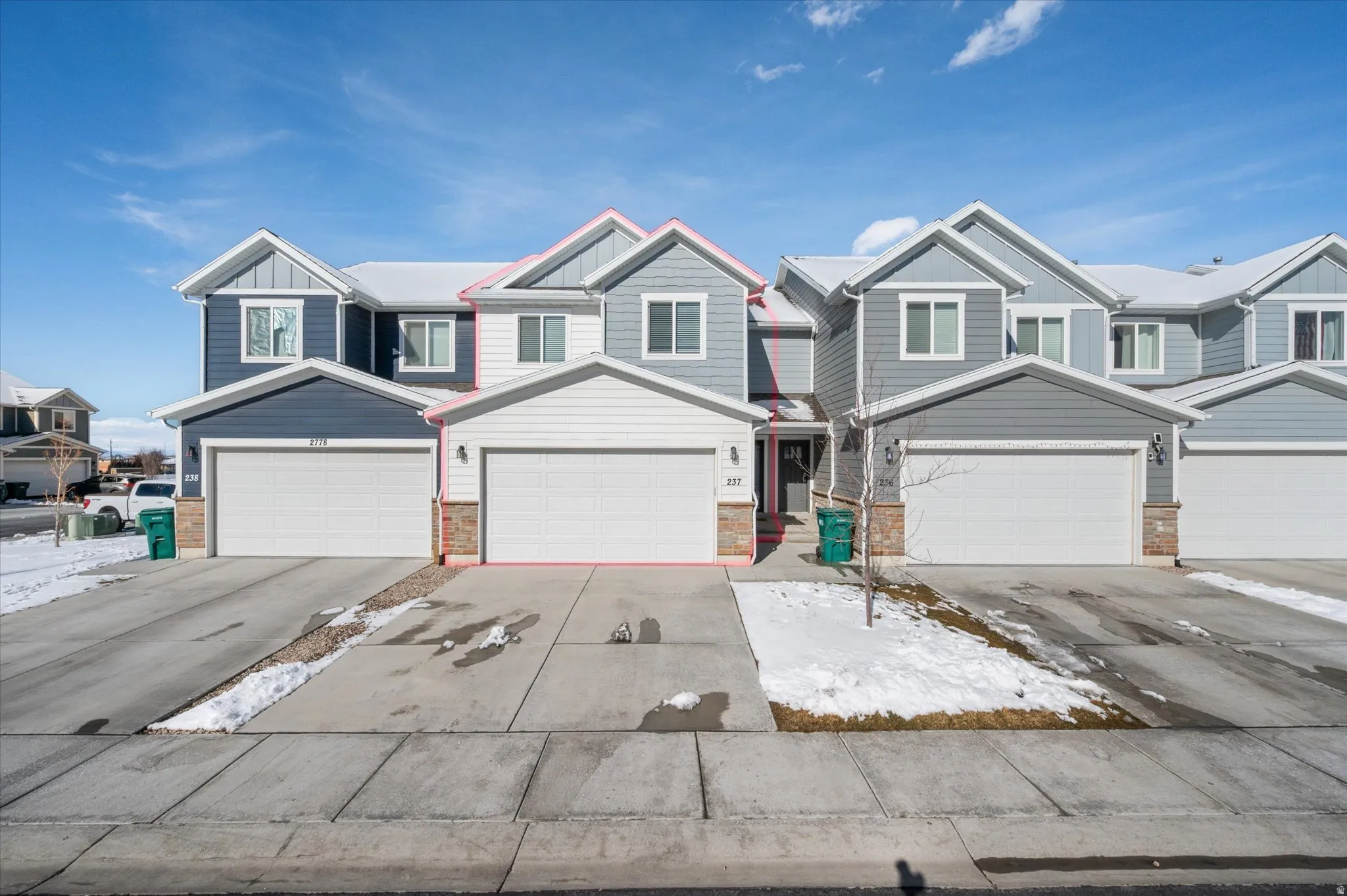View of front of home featuring board and batten siding, concrete driveway, and a residential view