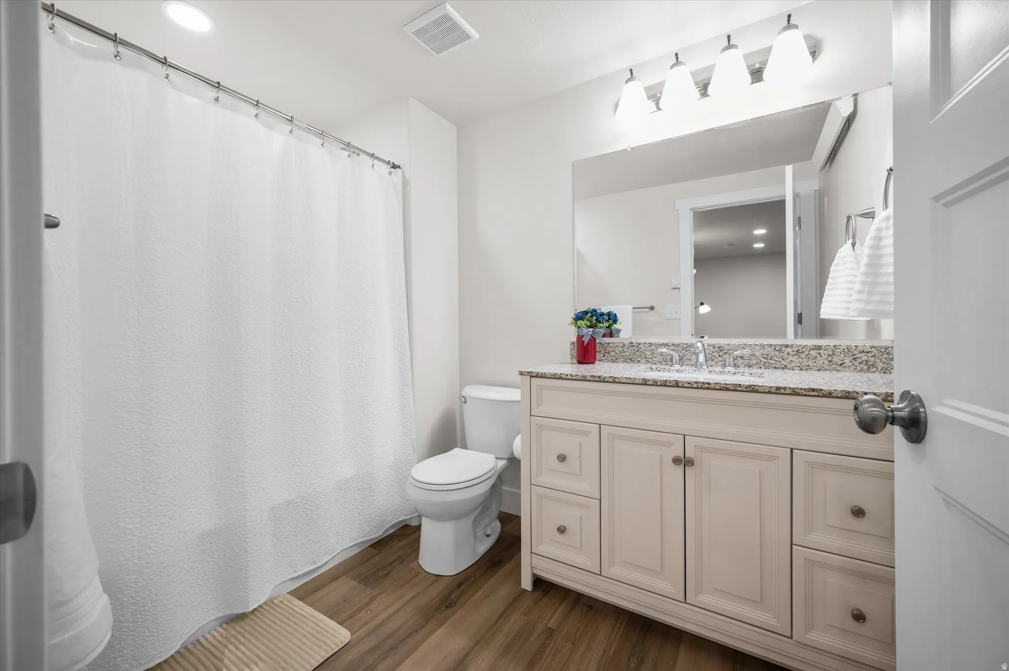 Full bath featuring vanity, recessed lighting, curtained shower, and dark wood finished floors