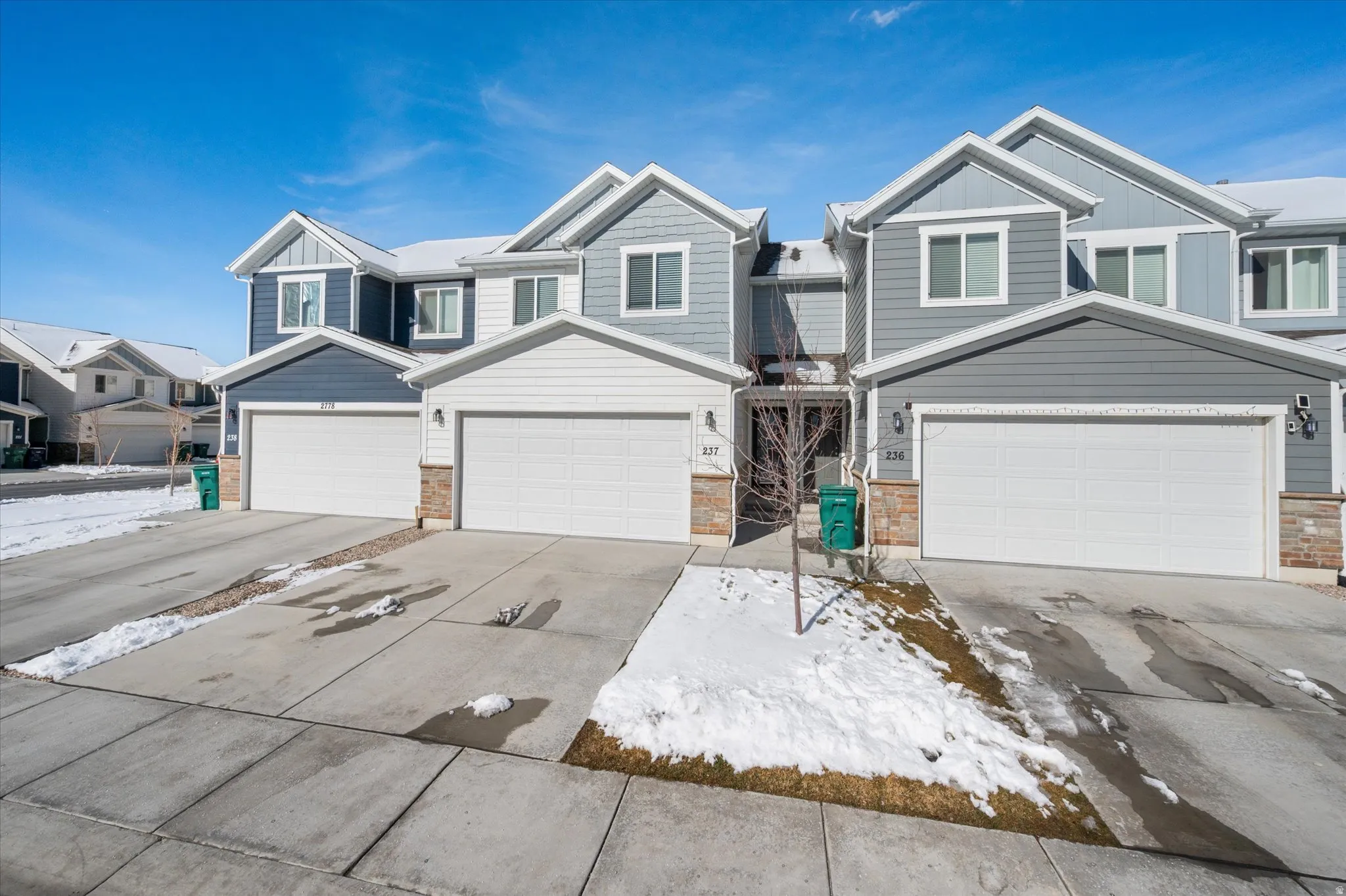 Craftsman-style house with board and batten siding, driveway, a residential view, and a garage
