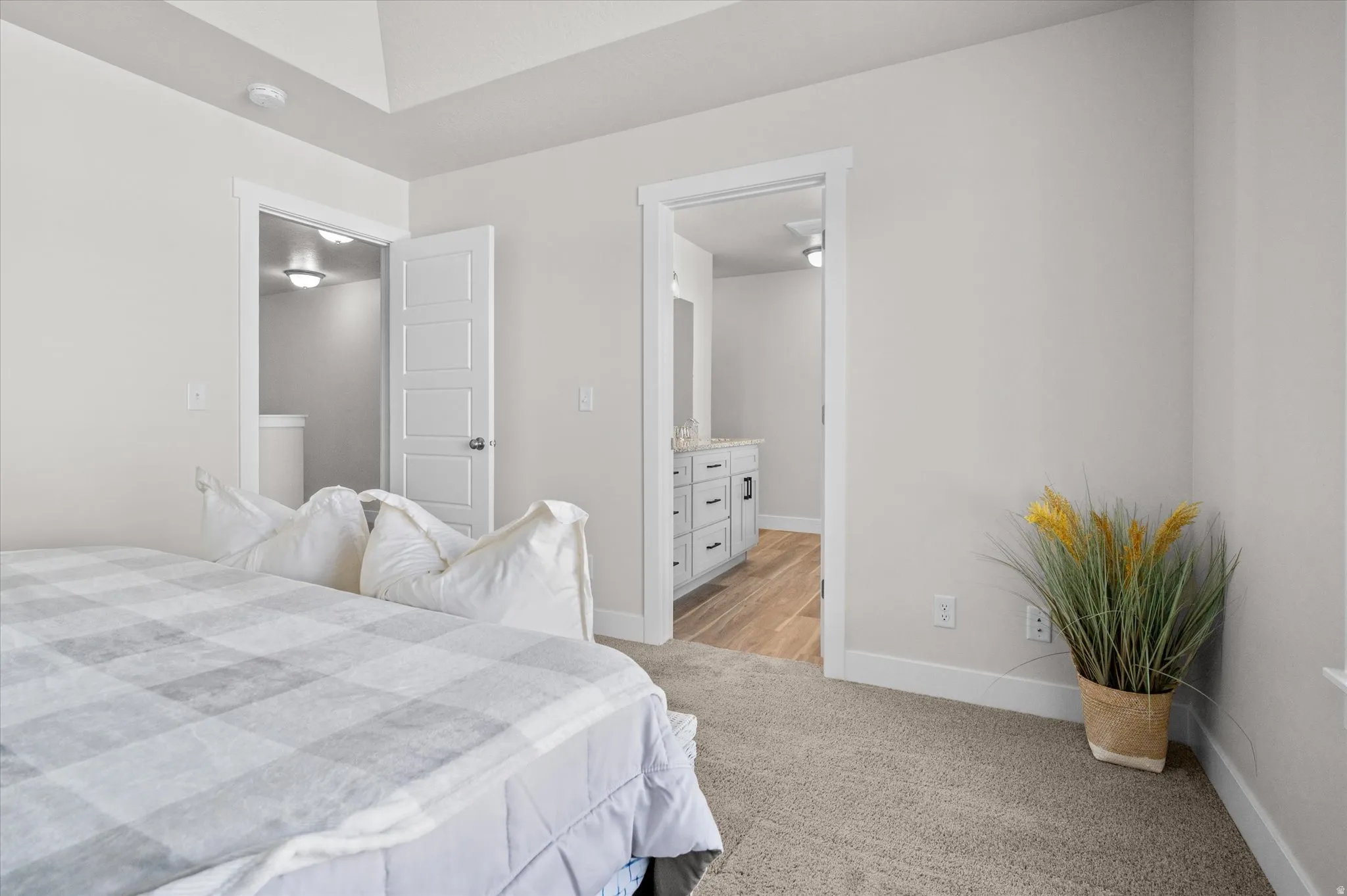 Bedroom with ensuite bathroom and light carpet