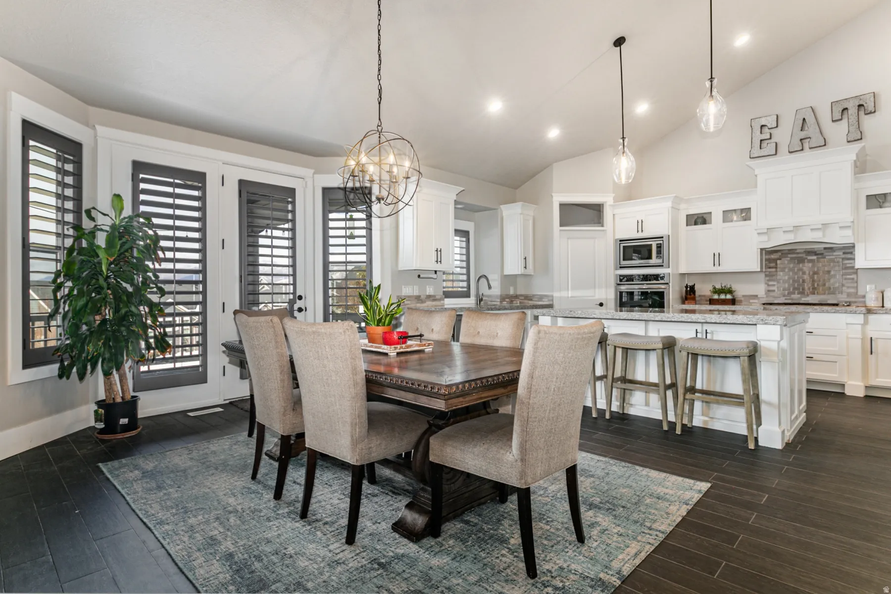 Dining room with vaulted ceiling, a chandelier, and dark wood-style flooring