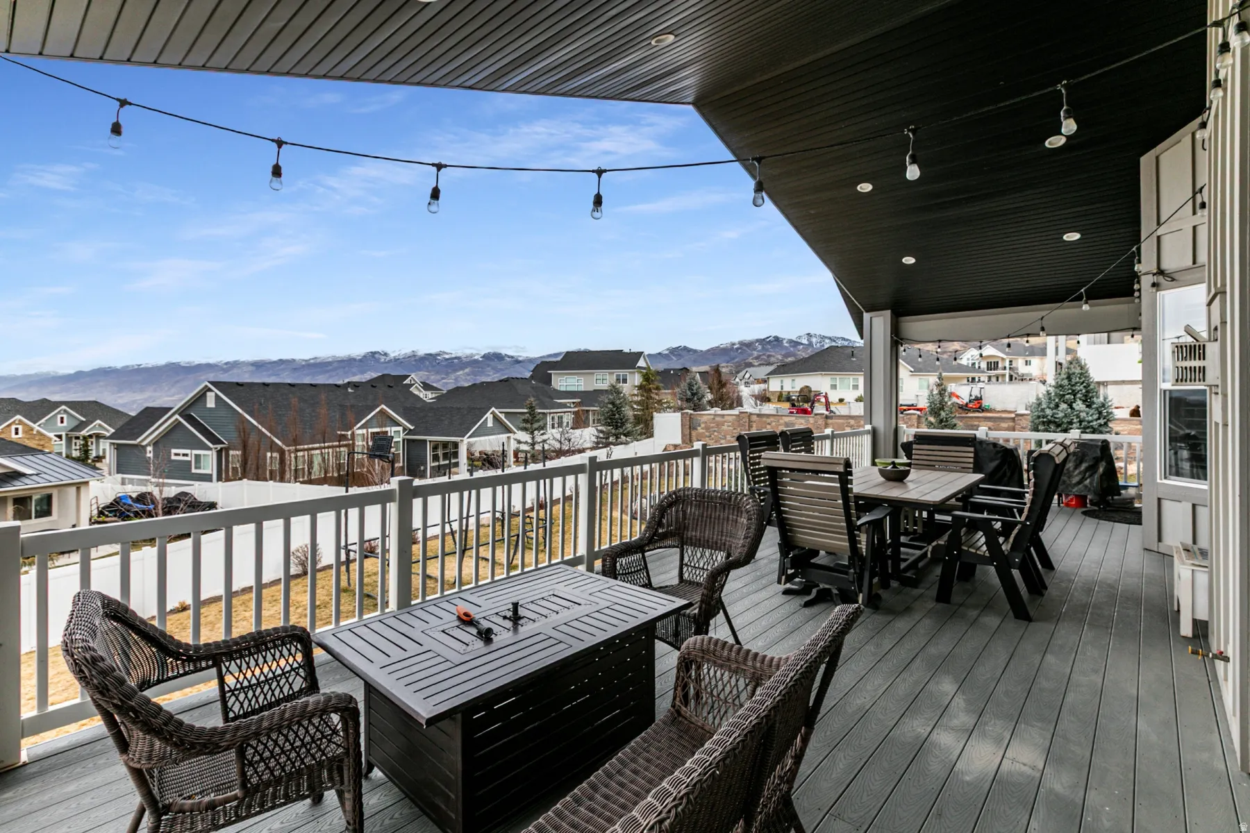 Wooden deck featuring outdoor dining space, a residential view, and a mountain view