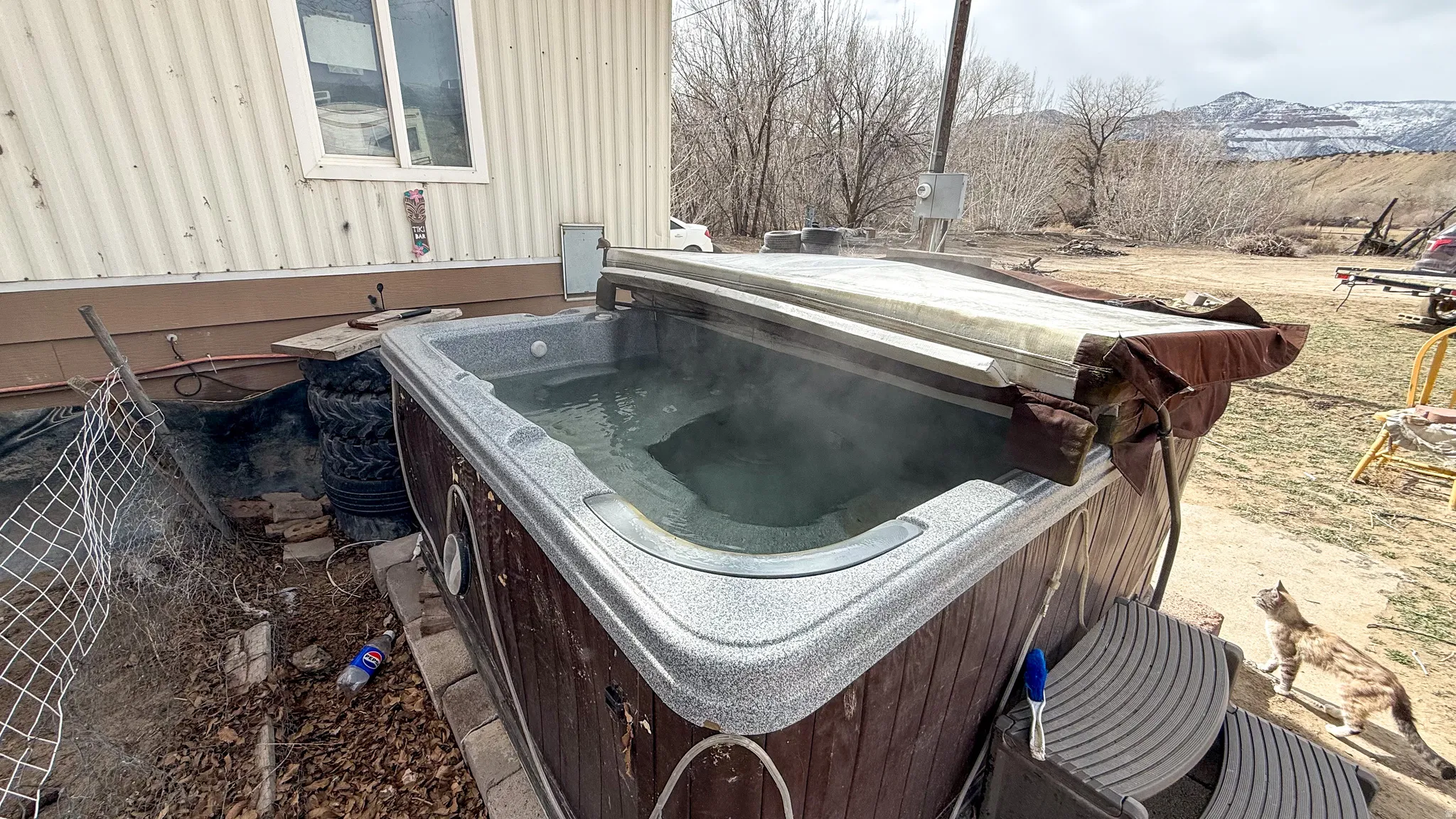 View of yard with a hot tub and a mountain view